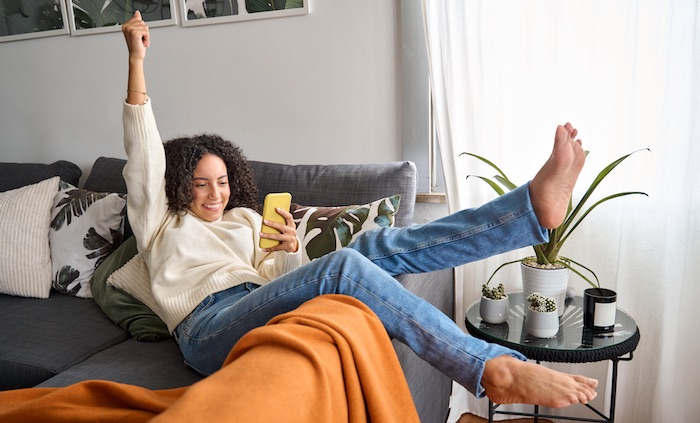 Happy excited woman relaxing on second chance thrift couch